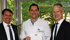 Alexander Zugsbradl (l.) und Dr. Andreas Tiete (r.) gratulieren PD Dr. Jürgen Lutz
