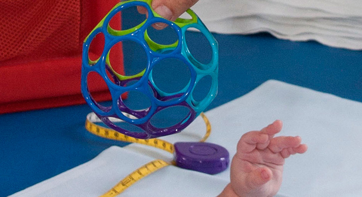 Säugling greift nach Plastikball